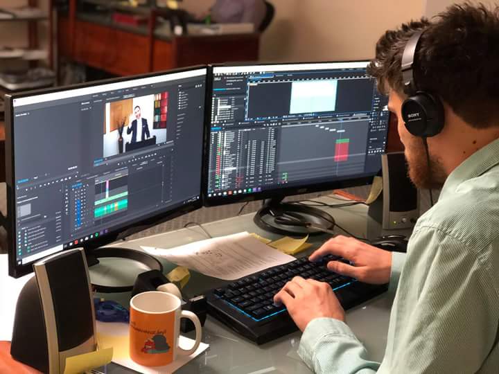 Image of a man at his desk editing a video