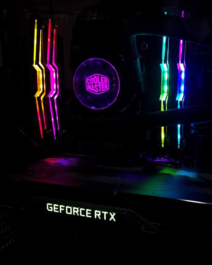 Image of 4 sticks of RGB RAM inside a PC, each one glowing a different colour